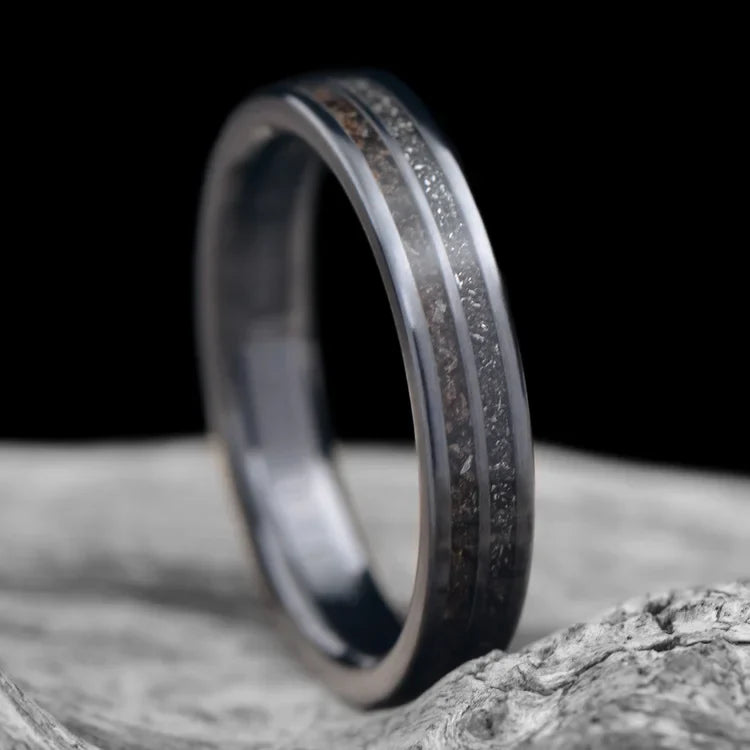 Black titanium wedding band with meteorite inlay, 4mm, custom simple ring, unique wedding band, free engraving, displayed on a white sea branch.