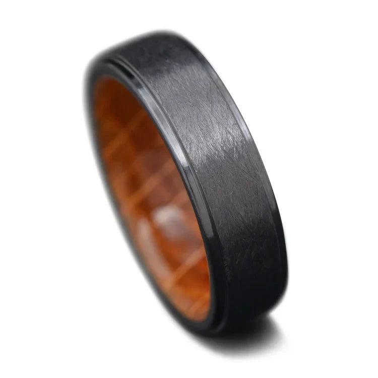 Black titanium wedding band with whiskey barrel oak inner sleeve, featuring a brushed stepped profile, 6mm mens ring, available with free engraving, displayed on a white background.