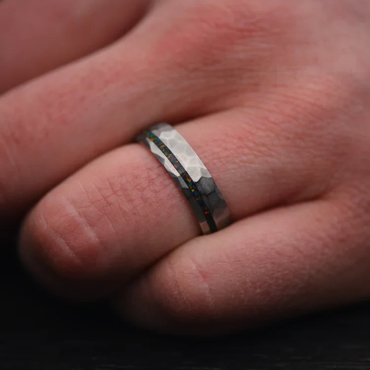 Mens titanium wedding band with black fire opal inlay, 6mm faceted domed design, unique and elegant, free engraving available, shown on hand.