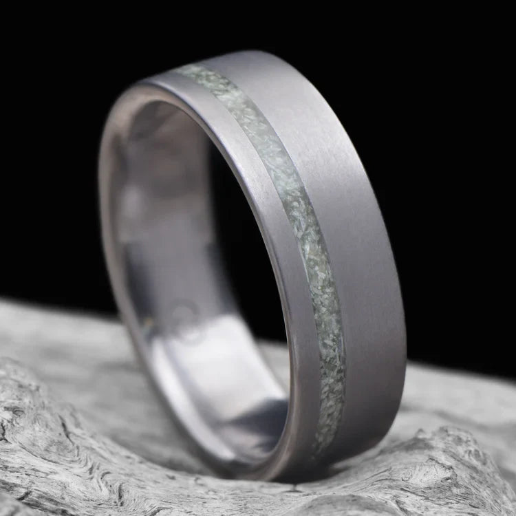 Tantalum wedding band with jade inlay, 7mm mens ring, brushed flat profile, unique design, free engraving, displayed on white sea branch.