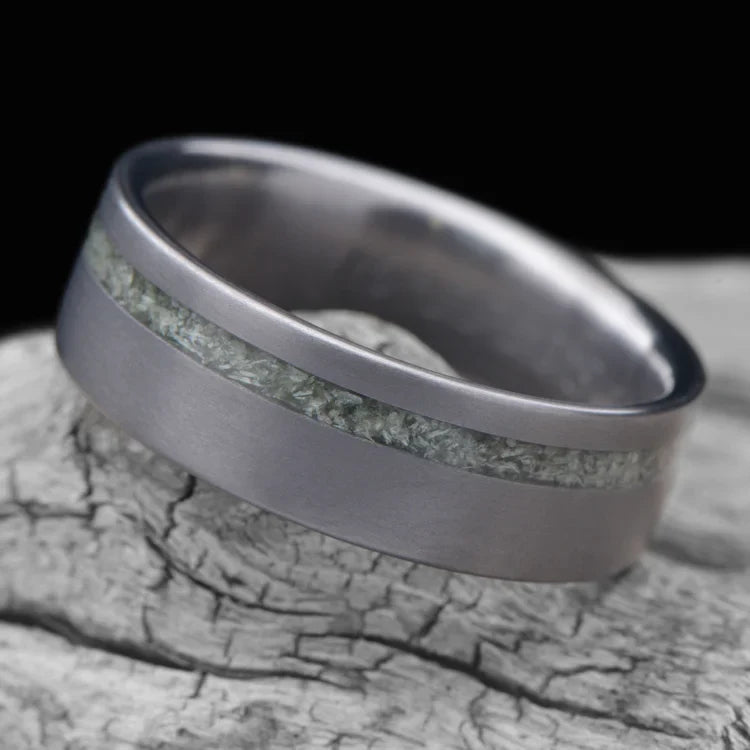 Tantalum wedding band with jade inlay, 7mm mens ring, brushed flat profile, unique design, free engraving, displayed on white sea branch.