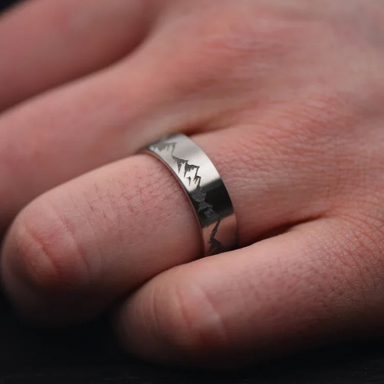 Mens 7mm titanium wedding band with brushed finish, custom engraved, shown on hand.
