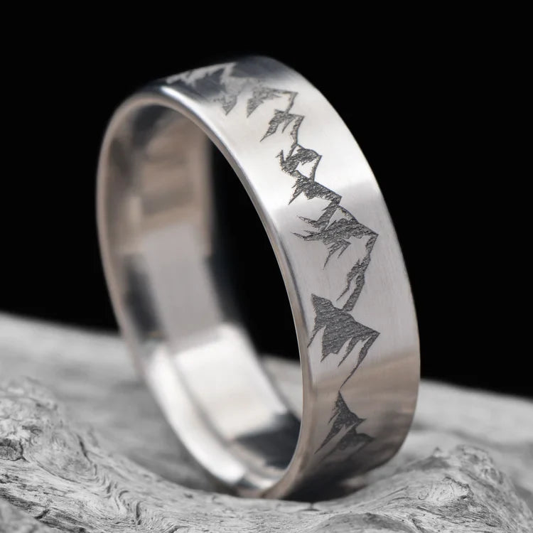 Titanium wedding band with brushed finish, 7mm mens ring, custom engraving available, displayed on white sea branch.