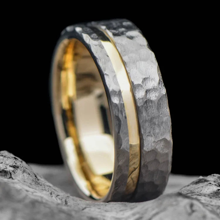 Titanium wedding band with 10KY inlay, featuring a faceted flat profile, 7mm mens ring, custom design, displayed on a white sea branch.