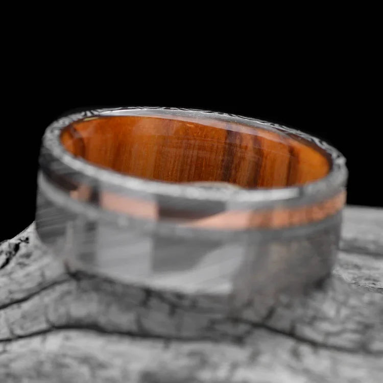 Heimskringla Wedding Band with 14K Rose Gold and Pearl Inlays, Mens 8mm Ring with Olivewood Inner Sleeve, Polished Flat Profile, displayed on a white sea branch.