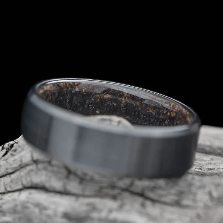 Black titanium wedding band with T-Rex inner sleeve, 8mm mens ring featuring a brushed bevel profile, displayed on a white sea branch, unique mens wedding ring with free engraving.