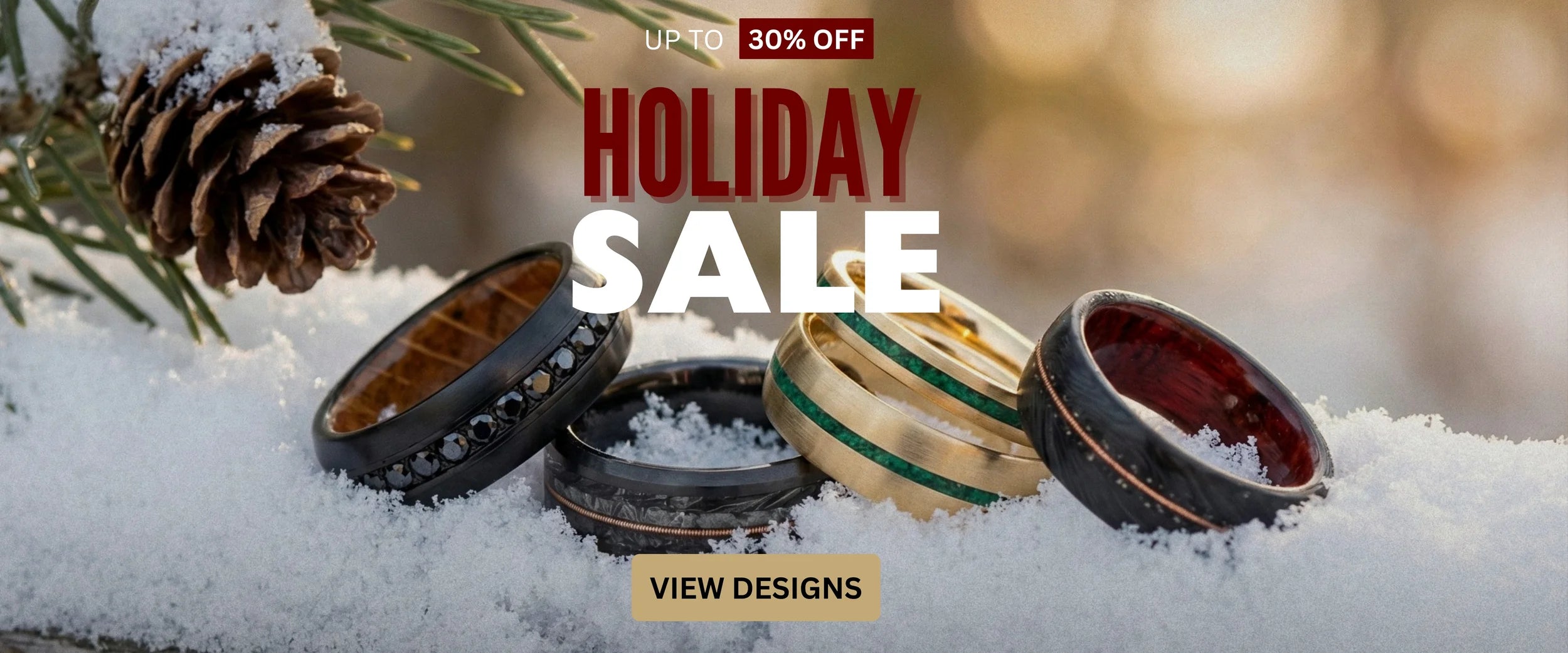 A holiday sale banner featuring custom men’s wedding rings displayed on snow. Text reads ‘Up to 30% Off Holiday Sale.’ Several rings in different materials—black, wood, gold, and green inlay—are arranged in the foreground with soft winter lighting. A button below says ‘View Designs.’”