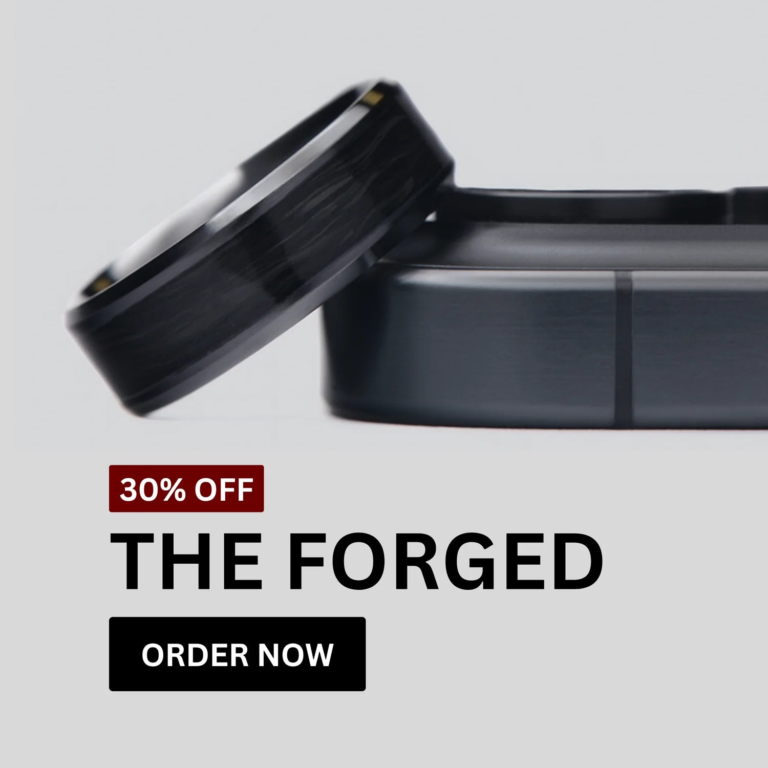 Forged carbon wedding ring from The Forged collection resting on a dark case. Text overlay reads ‘30% Off – The Forged’ with an ‘Order Now’ button on a light grey background