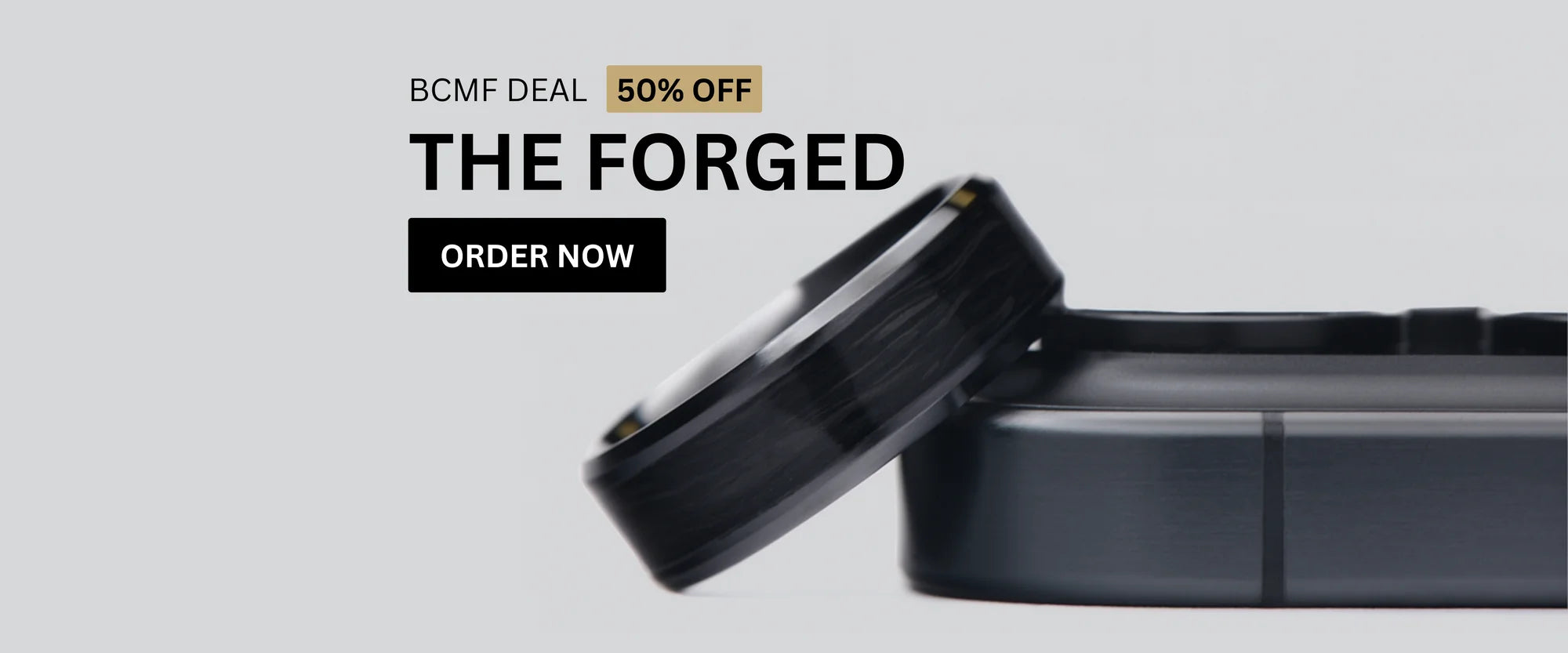 Close-up image of The Forged forged-carbon wedding ring displayed with a 50% off Black Friday offer.