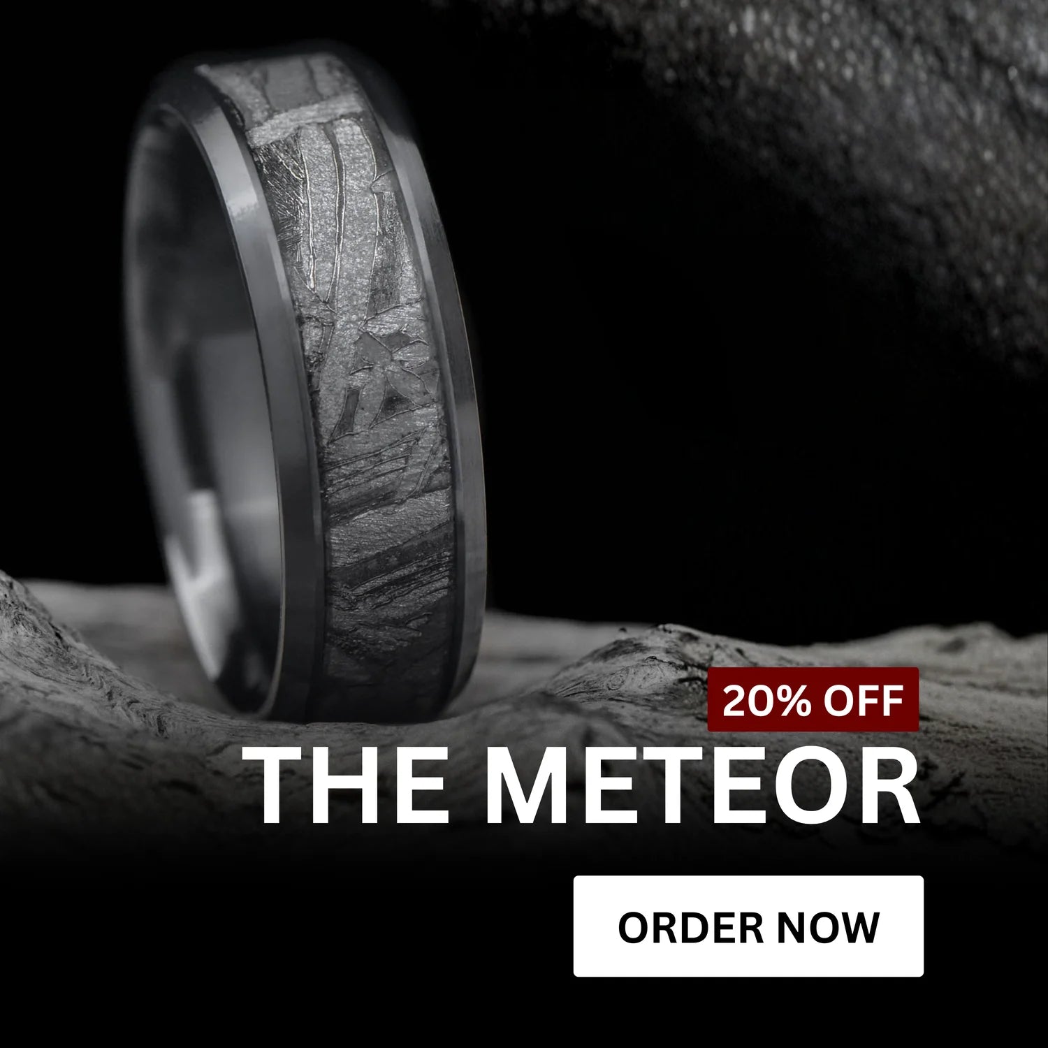 Meteorite wedding ring from The Meteor collection displayed on a textured rock surface. The ring features a dark band with a natural meteorite inlay pattern. Text overlay reads ‘20% Off – The Meteor’ with an ‘Order Now’ button