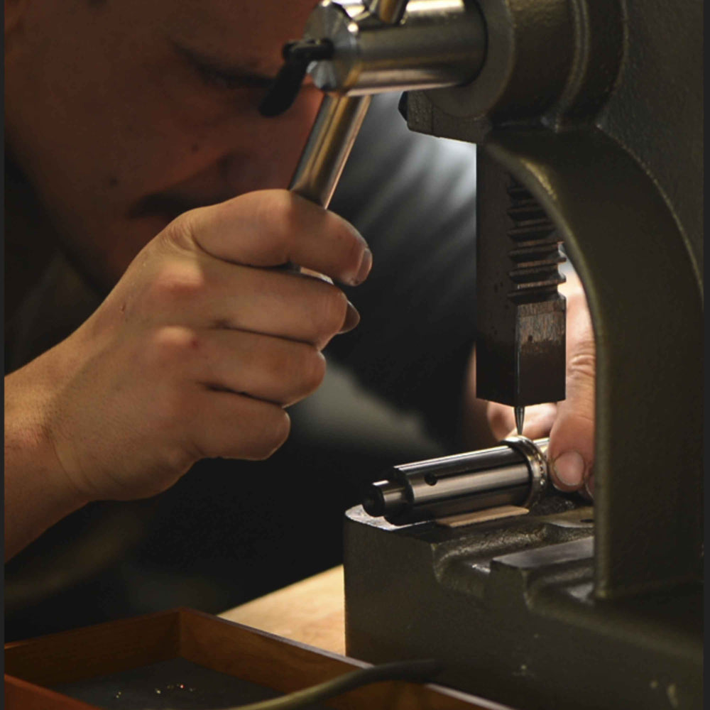 Jeweller hand fitting inlay material into a custom wedding ring at the Sesto Synergy bench.