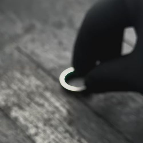 Video of a titanium wedding band with central forged inlay and black emerald opal sleeve, featuring free engraving, 6mm width, unique mens wedding ring showcased with black gloves.